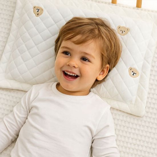 bebe-souriant-allonge-sur-oreiller-bebe-ourson