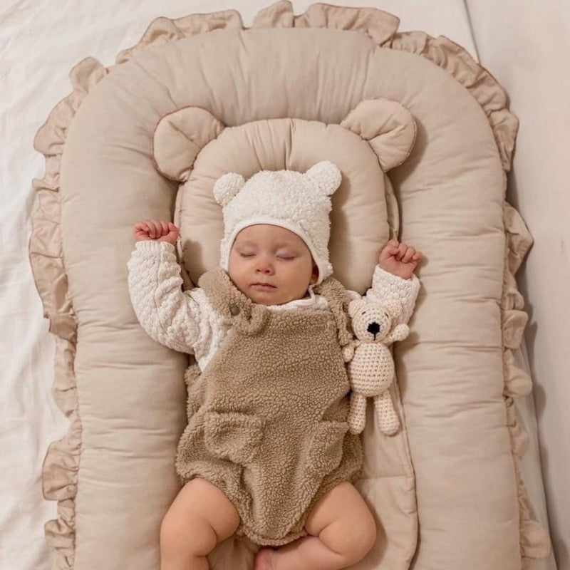 bebe_dort_dans_reducteur_de_lit_bebe_beige_avec_son_doudou