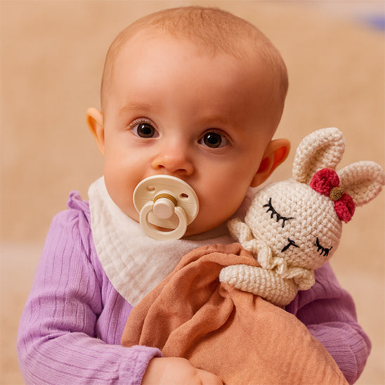 bebe qui sert doudou bebe nin nin en forme de lapin dans ses bras