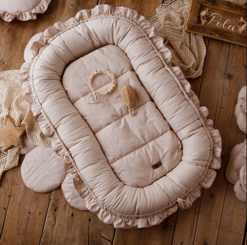 reducteur_de_lit_bebe_beige_pose_sur_le_parquet_bois