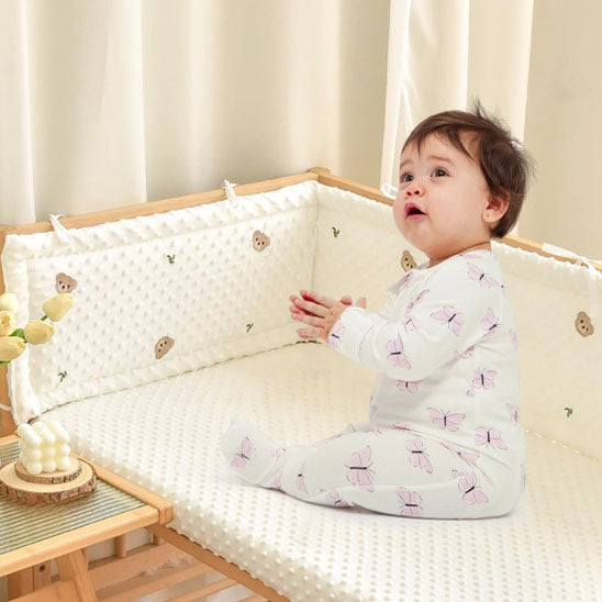 bebe-assis-dans-son-lit-entoure-du-tour-de-lit-bebe-coton-velours