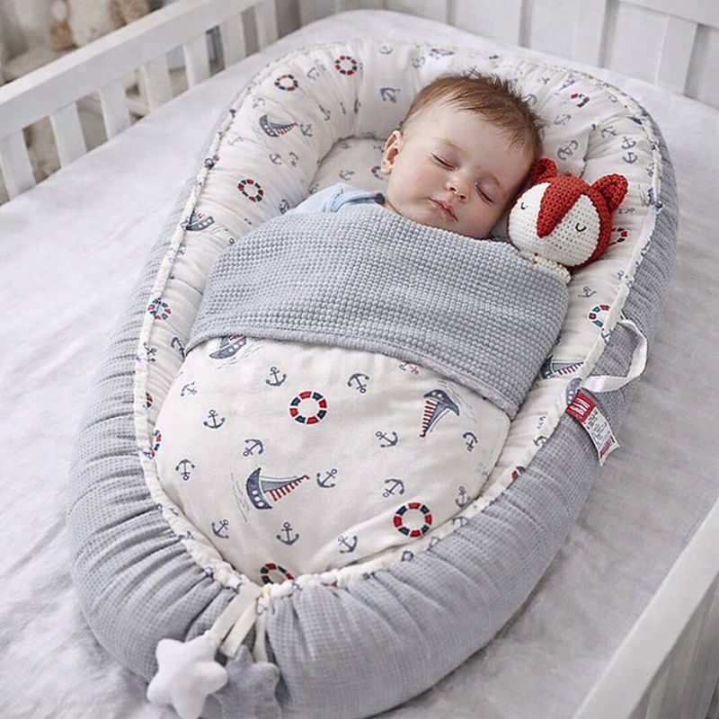bebe-endormi-paisiblement-dans-reducteur-de-lit-bebe-cocon-marin