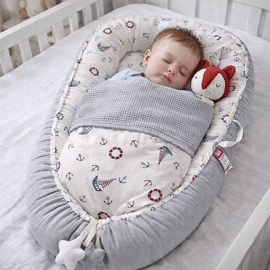 bebe-endormi-paisiblement-dans-reducteur-de-lit-bebe-cocon-marin