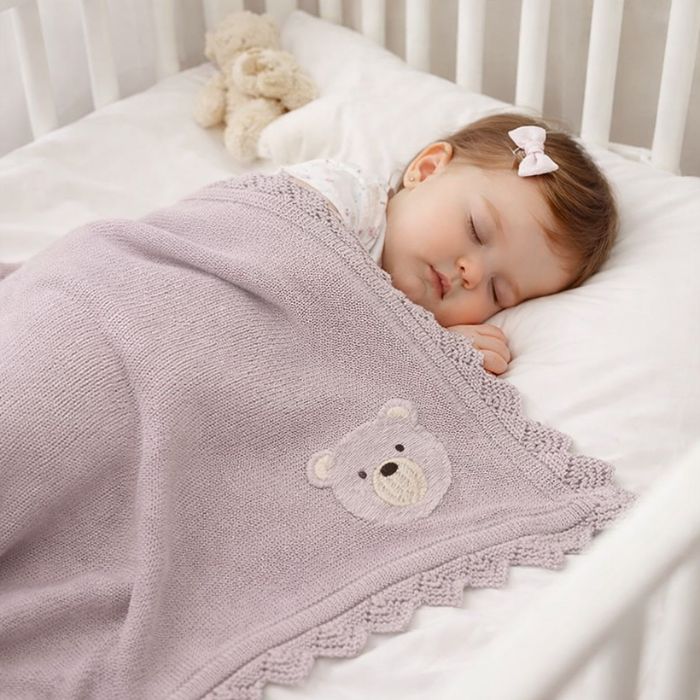 bebe-fille-endormie-couverte-par-couverture-bebe-tricot-ourson-mauve