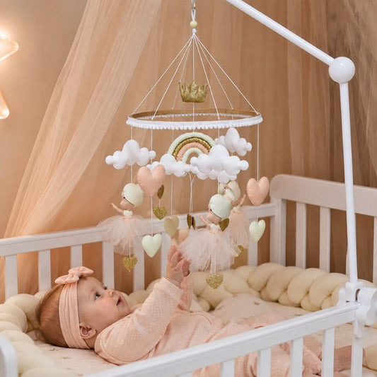 bébé allongée sur le dos regarde et tend la main vers mobile bébé danse féerique