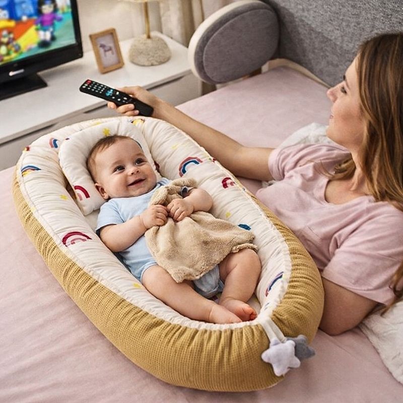 bebe-joyeux-dans-le-reducteur-de-lit-bebe-nestea-avec-sa-maman