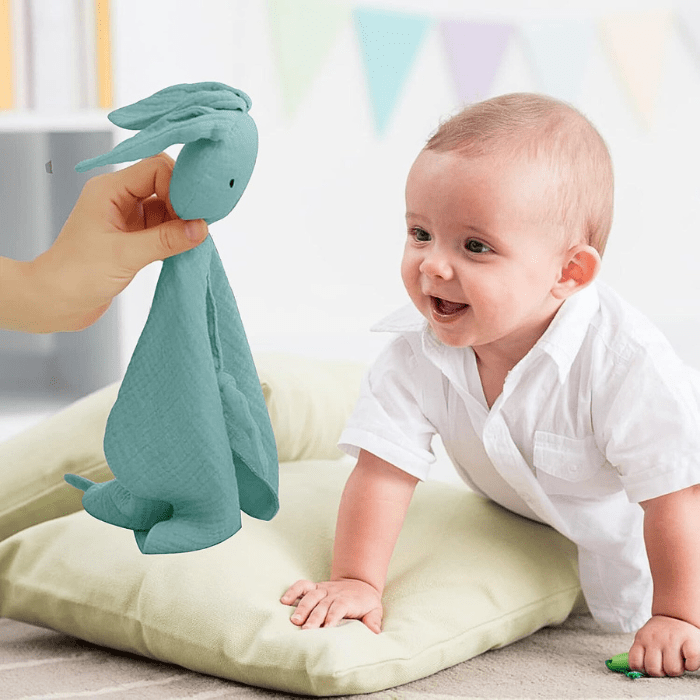 bebe-souriant-avec-doudou-bebe-pinou-bleu