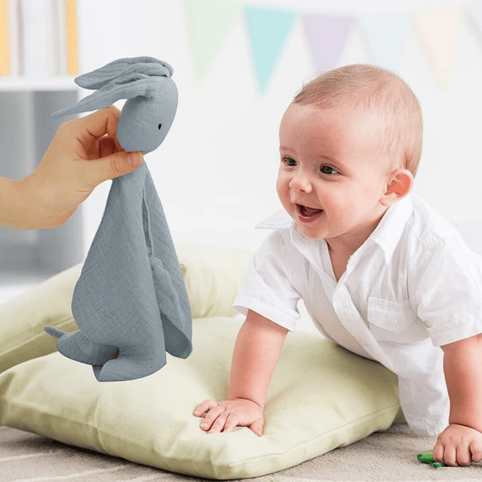 bebe-souriant-avec-doudou-bebe-pinou-gris