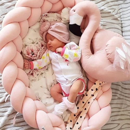 bebe_fille_dort_dans_le_reducteur_de_lit_bebe_tresse_rose_avec_une_peluche_signe