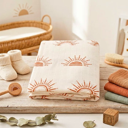 couverture bebe motif soleil en gaze de coton pliee avec des accessoires bebe