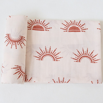 couverture bebe motif soleil en gaze de coton roulee sur le cote 