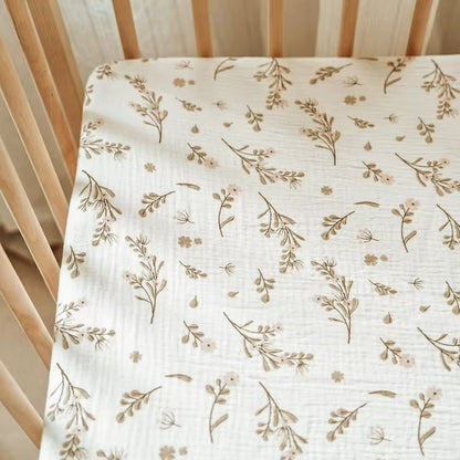 Drap housse bebe en gaze de coton motif floral champetre pose sur lit a barreaux en bois naturel avec texture gaze visible