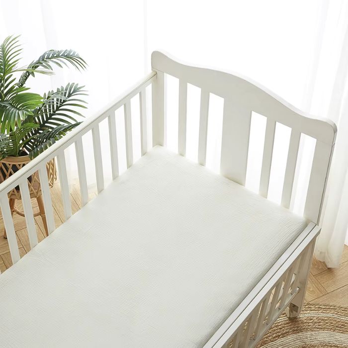 drap housse bébé gaze de coton blanc dans lit blanc à barreaux 