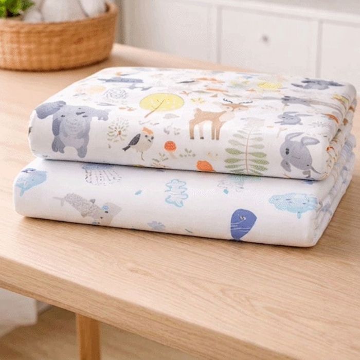 drap housse lit bébé forêt et océan pliés
