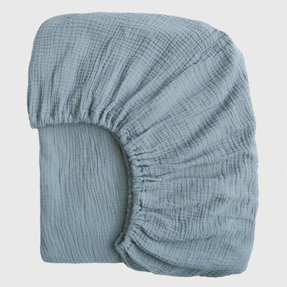 drap housse lit bébé gaze de coton bleu avec élastiques plié