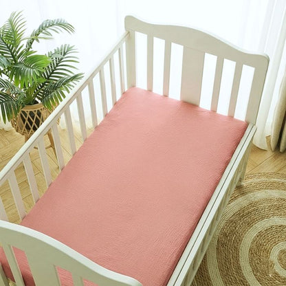Drap housse pour matelas 70 x 140 cm coton doux rose poudré uni sur lit à barreaux blanc, chambre bébé lumineuse et naturelle