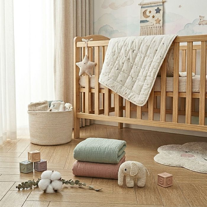 Drap housse pour matelas 70 x 140 cm - rose poudré et vert sauge posés au sol dans la chambre de bébé