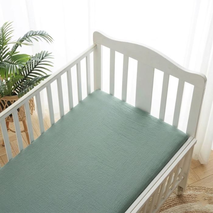 Drap housse pour matelas 70 x 140 cm coton doux vert sauge uni sur lit à barreaux blanc, chambre bébé lumineuse et naturelle