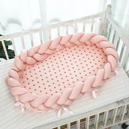 reducteur_de_lit_bebe_tresse_rose_dans_le_lit_de_bebe