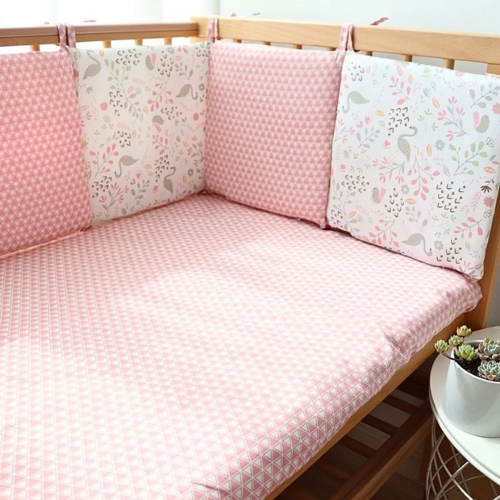 tour de lit bébé flamants et roses pare-chocs et drap housse rose dans lit bois naturel